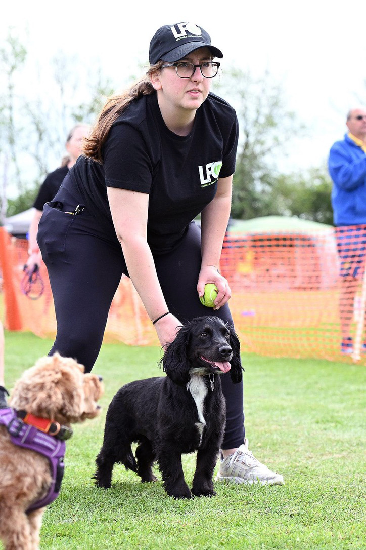 A black cocker spaniel and his handler get ready to race